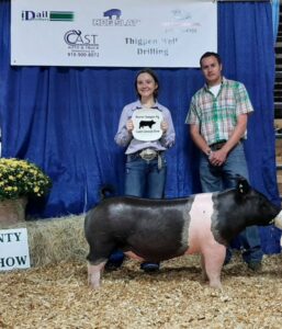 A girl poses with her prize winning pig.