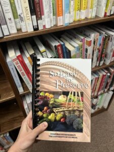 image of So Easy To Preserve book held in front of a bookcase